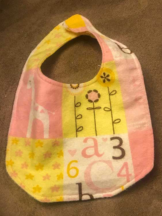 pink, yellow, and white baby bib